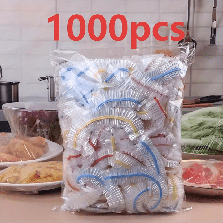 Sachet de couvercles élastiques à bandes colorées sur un plan de travail, entouré d'assiettes de viande, de légumes et de pâtes filmées. 3