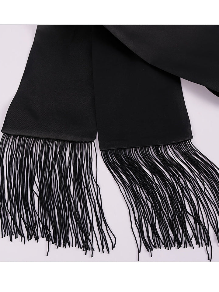 Gros plan sur les deux extrémités de la ceinture noire, terminées par de longues franges 8