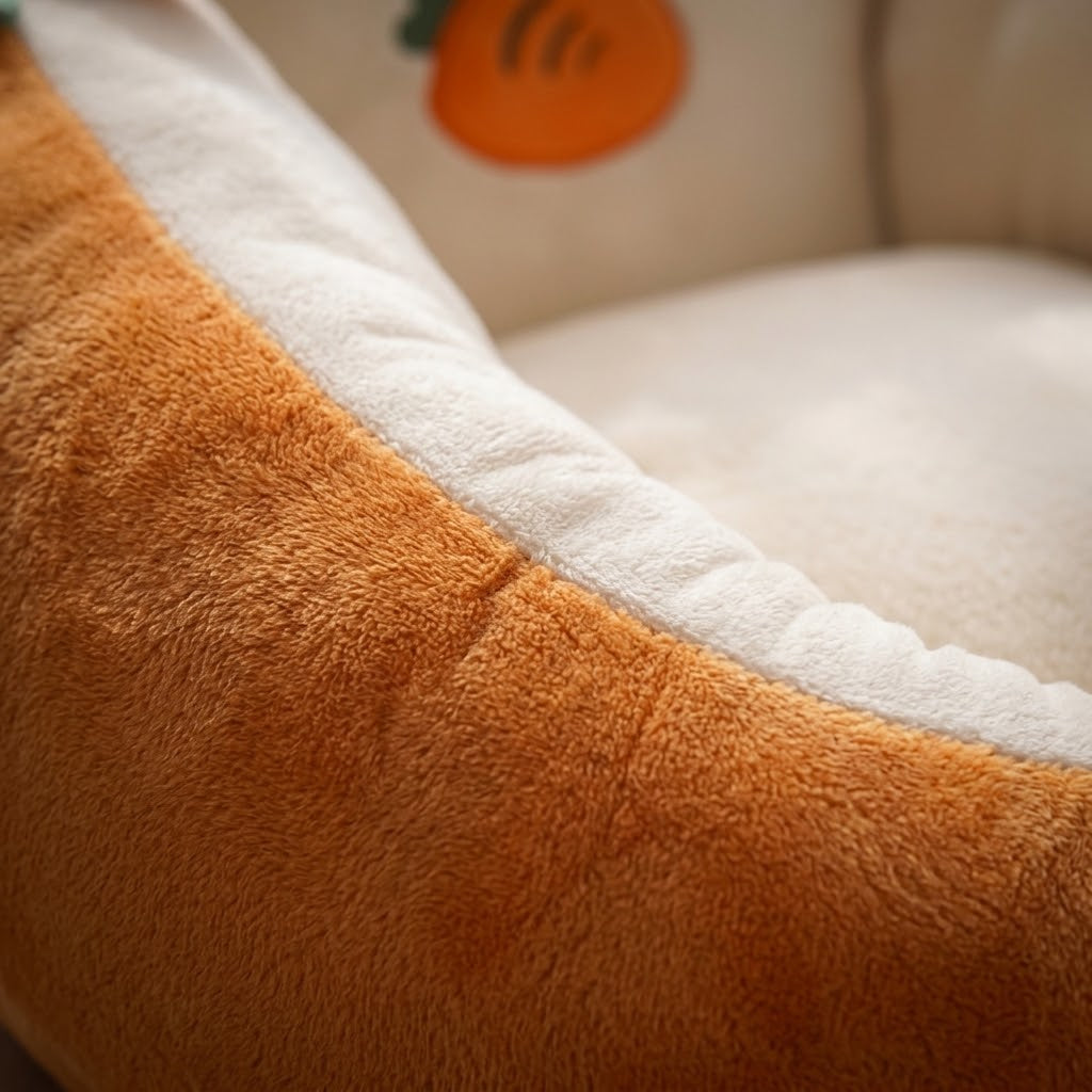 Gros plan sur le tissu doux et duveteux orange et crème du fauteuil carotte, avec sa couture 2