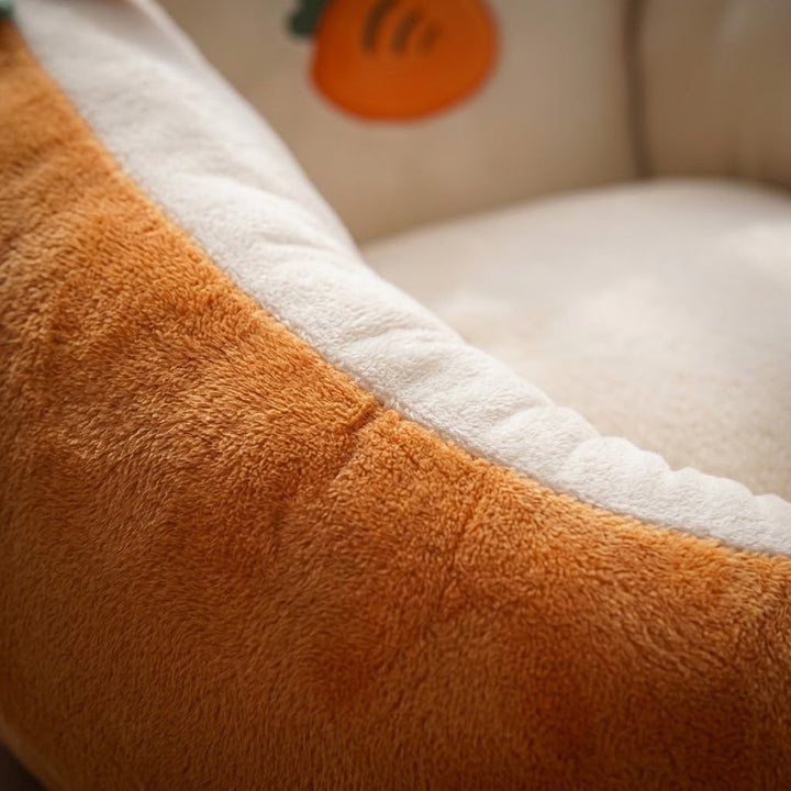Gros plan sur le tissu doux et duveteux orange et crème du fauteuil carotte, avec sa couture 2