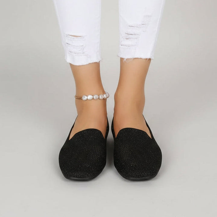 Paire noire pailletée portée de face avec un jean blanc déchiré, sur fond gris uni. 2