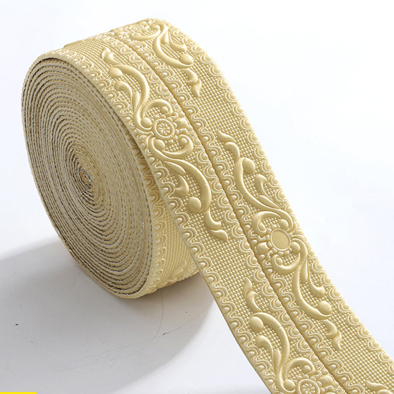 Rouleau de bordure beige doré en relief, motifs floraux et volutes sur fond quadrillé, posé sur fond blanc. 9