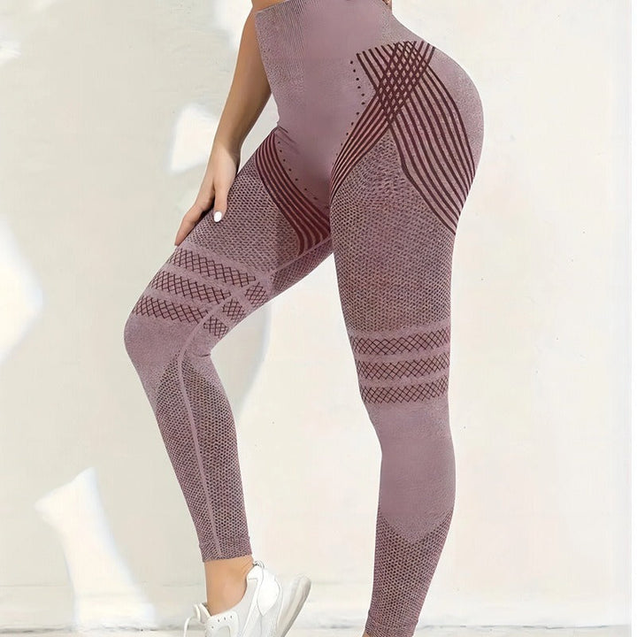 Legging taille haute rose poudré porté de profil, avec rayures croisées sur la hanche et bandes ajourées sur les cuisses. 22