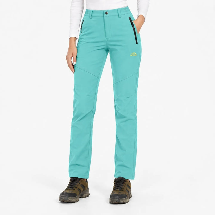 Pantalon turquoise porté de face par une mannequin avec chaussures de randonnée 19