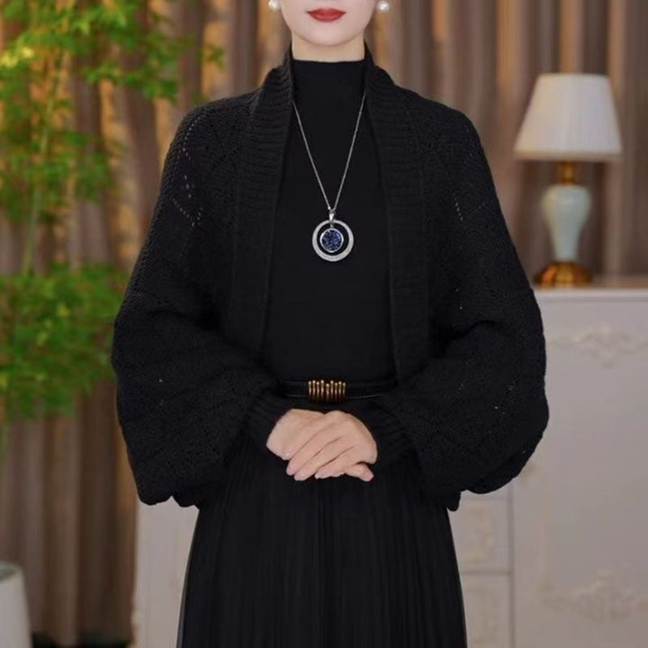 Cardigan ajouré noir porté par un mannequin sur une robe plissée noire, col châle côtelé 3