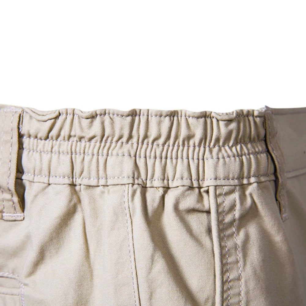 Gros plan sur la ceinture élastique froncée du short beige, avec ses surpiqûres et ses passants. 4