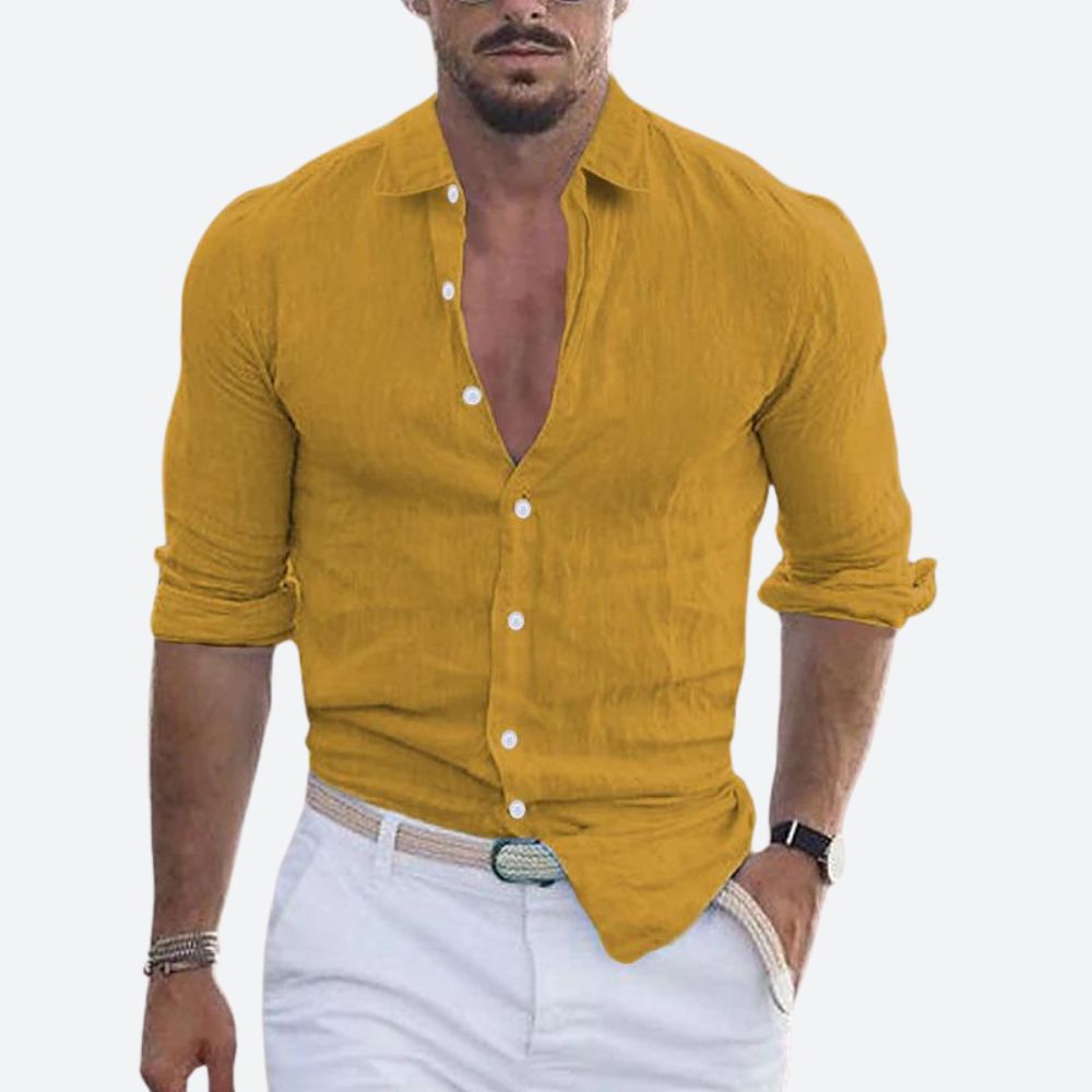 Chemise jaune moutarde portée par un homme, col ouvert, manches retroussées, avec pantalon blanc et ceinture tressée. 2