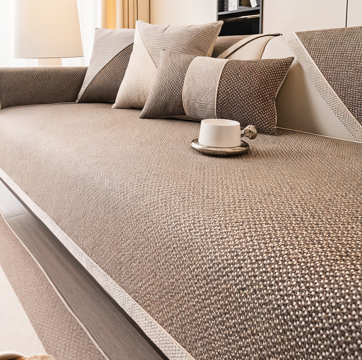 Housse marron taupe au tissu texturé couvrant l'assise du canapé, avec coussins assortis et tasse blanche posée dessus. 10
