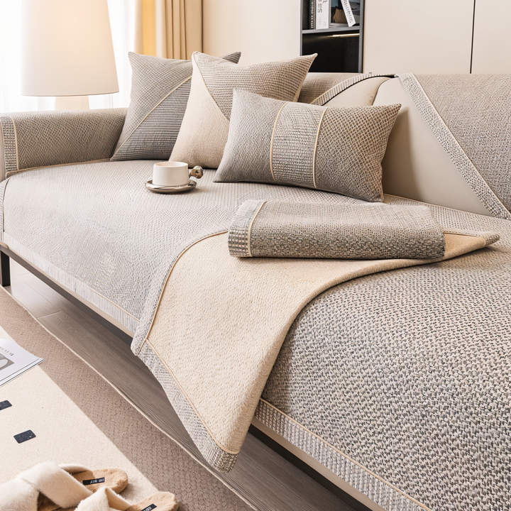 Housse beige-gris dont un pan est replié sur l'assise, révélant la face inférieure beige et le bord tissé quadrillé. 3