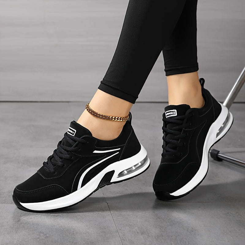 Baskets noires à lacets et bandes blanches portées jambes croisées avec un legging noir, mettant en valeur la semelle à coussin d'air. 5
