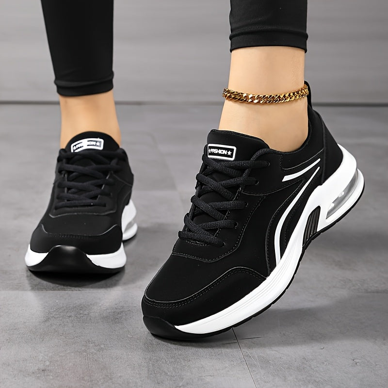 Vue de face et de trois quarts de baskets noires lacées à bandes blanches, portées avec un legging noir et une chaîne de cheville dorée. 2