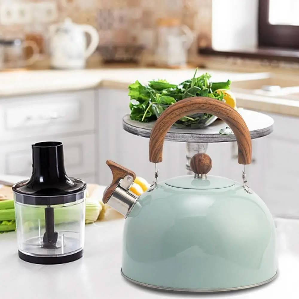 Bouilloire vert d'eau sur un plan de travail de cuisine, à côté d'un mixeur 4