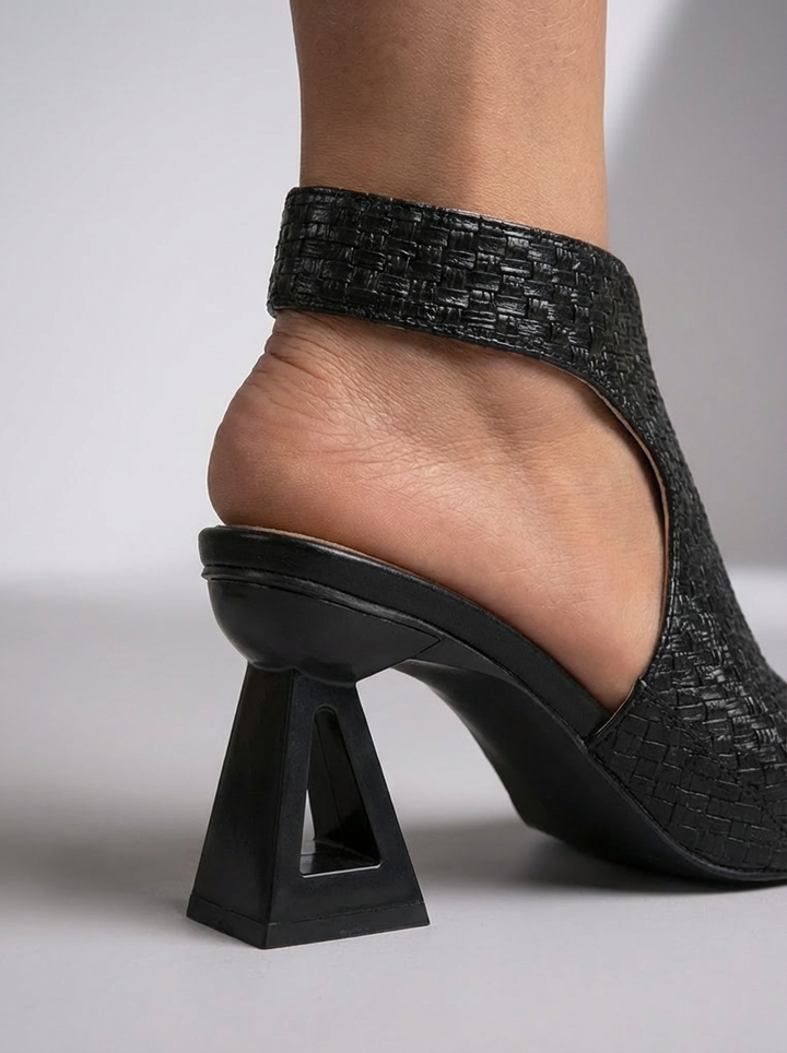 Gros plan sur l'arrière d'une sandale noire tissée, avec sa bride talon et son talon ajouré 7