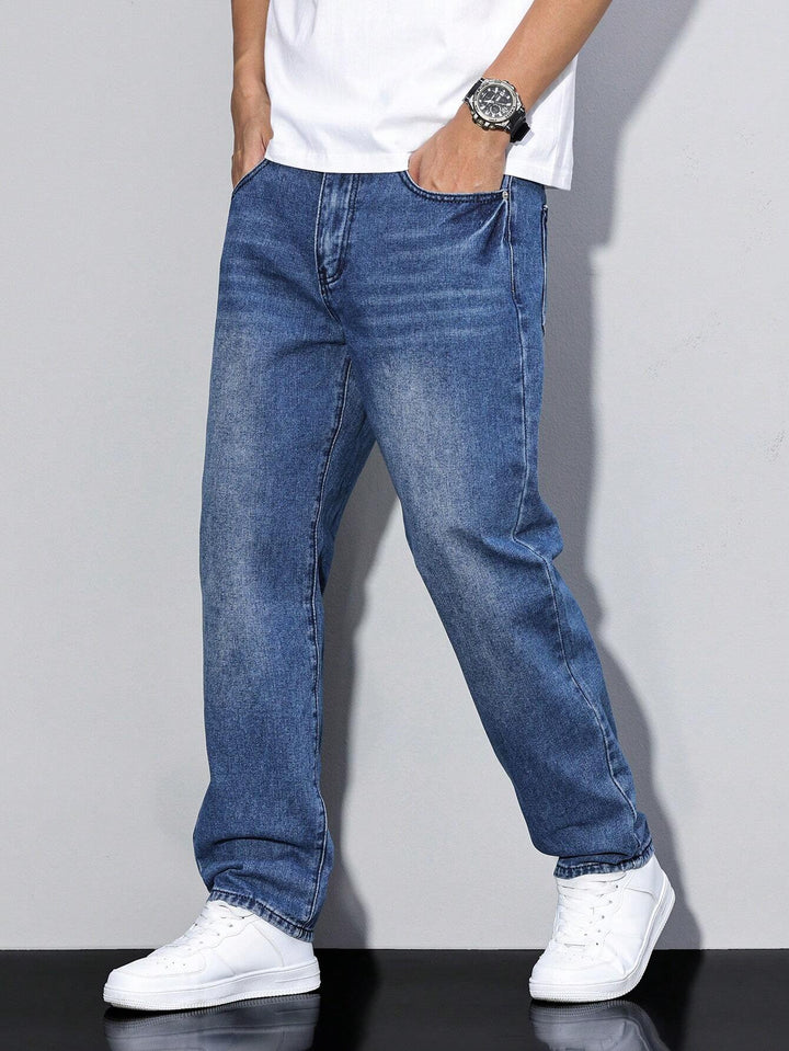 Jean baggy bleu foncé légèrement délavé, coupe droite, porté les deux mains dans les poches avec des baskets blanches. 12