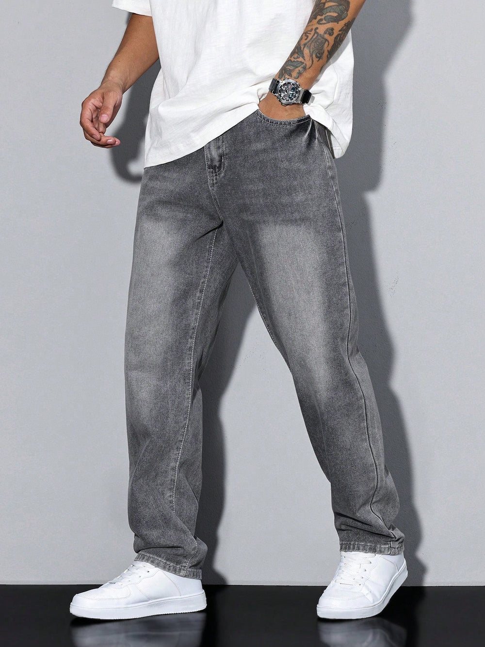 Jean gris délavé porté de face par un modèle, main dans la poche avant, avec t-shirt blanc et baskets blanches. 2
