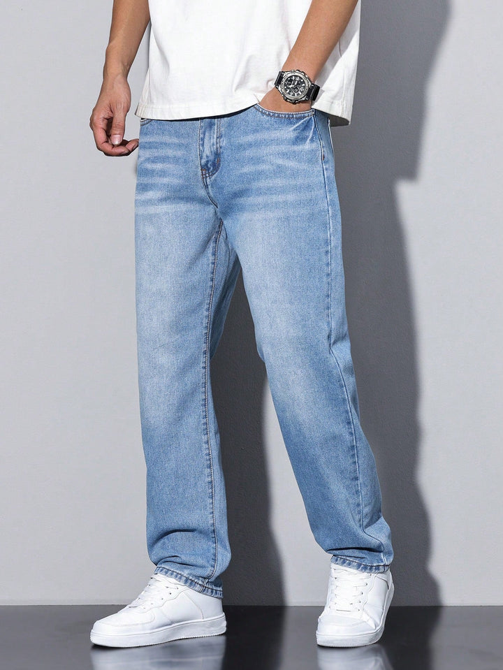 Jean en denim bleu clair délavé porté de face, main dans la poche, coupe large et jambes droites. 7