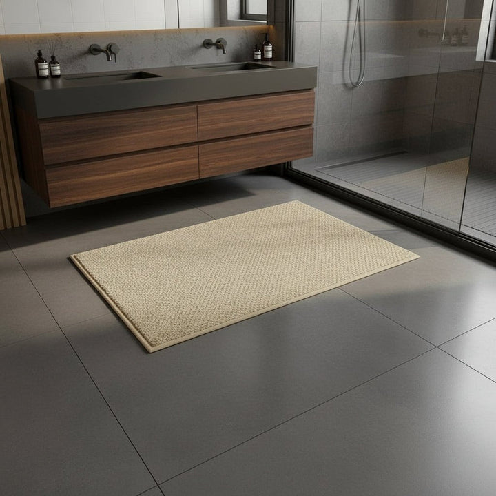 Tapis beige à bordure assorti posé sur un carrelage gris devant un meuble vasque en bois sombre 2