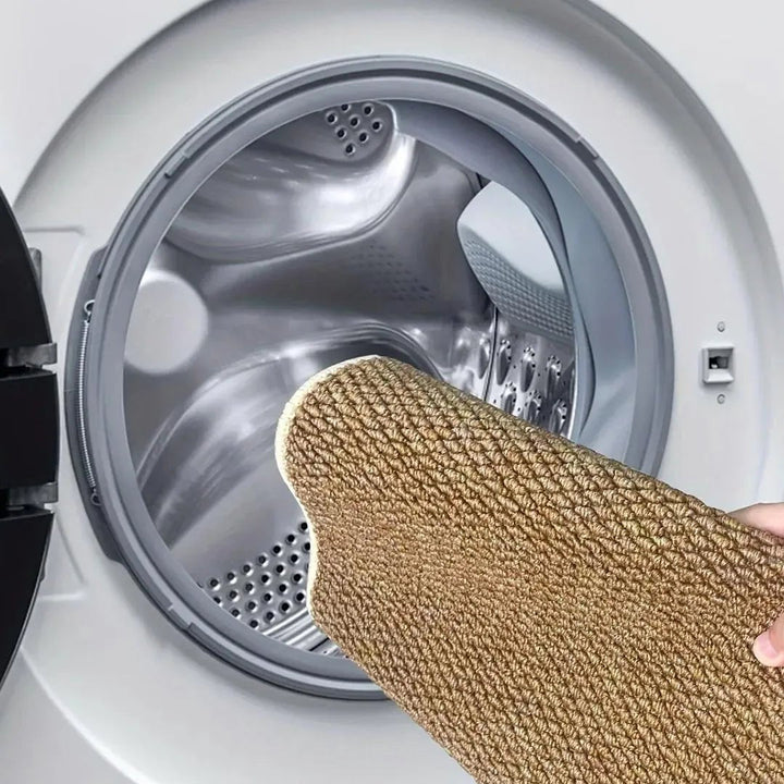 Tapis brun clair tenu à la main devant le tambour ouvert d'un lave-linge, pour illustrer le lavage en machine 7
