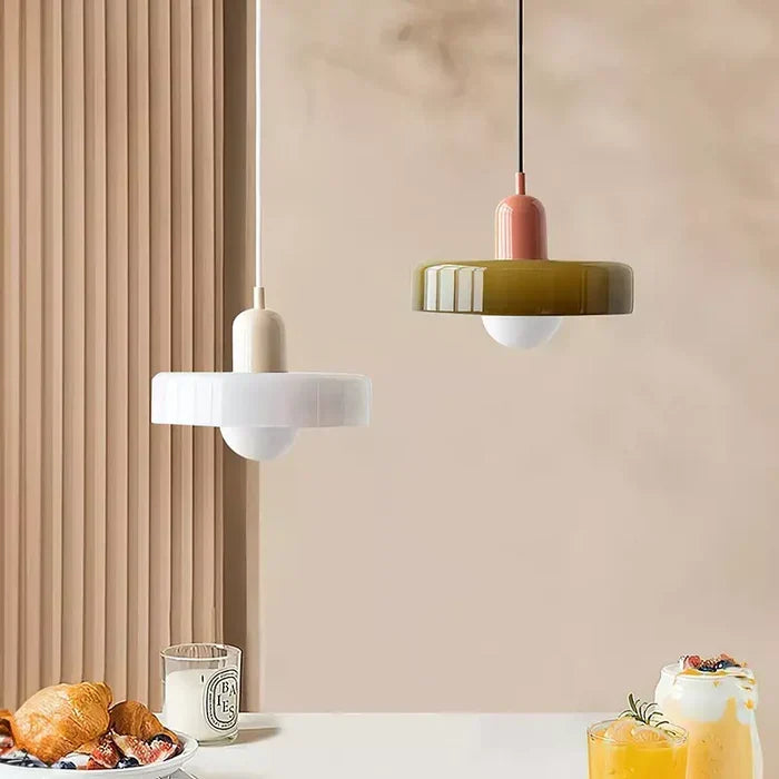 Deux suspensions dans une ambiance de petit-déjeuner : abat-jour en verre blanc à capuchon beige, et verre vert olive à capuchon rose. 31