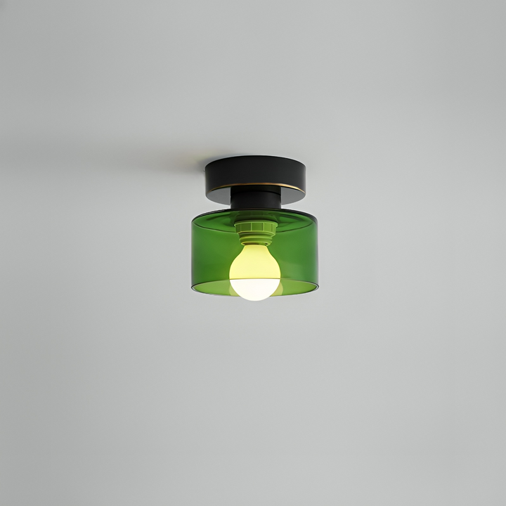 Spot à base noire et abat-jour en verre vert translucide laissant voir l'ampoule allumée, fixé au plafond. 10