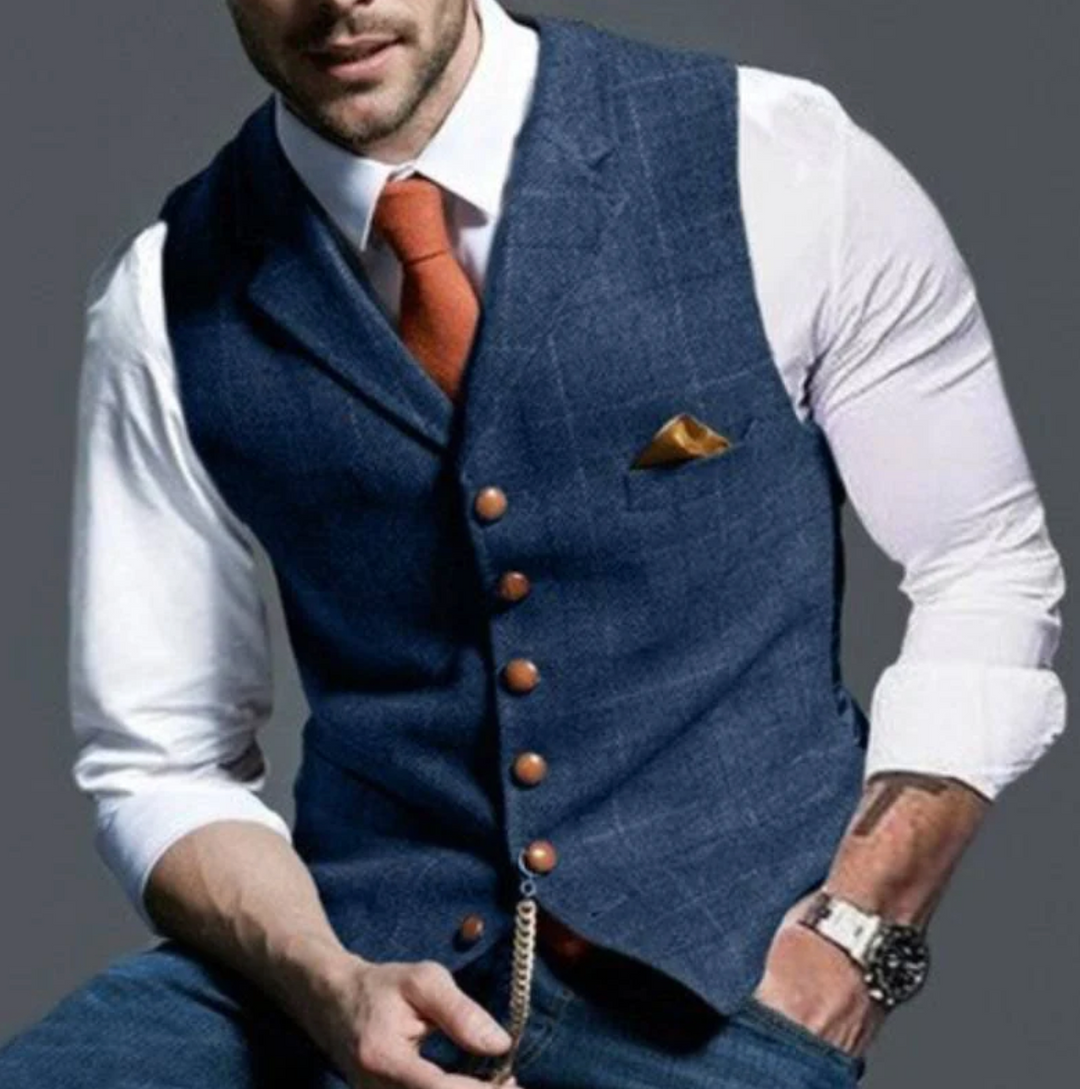 Gilet bleu marine porté par un homme avec chemise blanche, cravate orange et chaîne de gousset 1