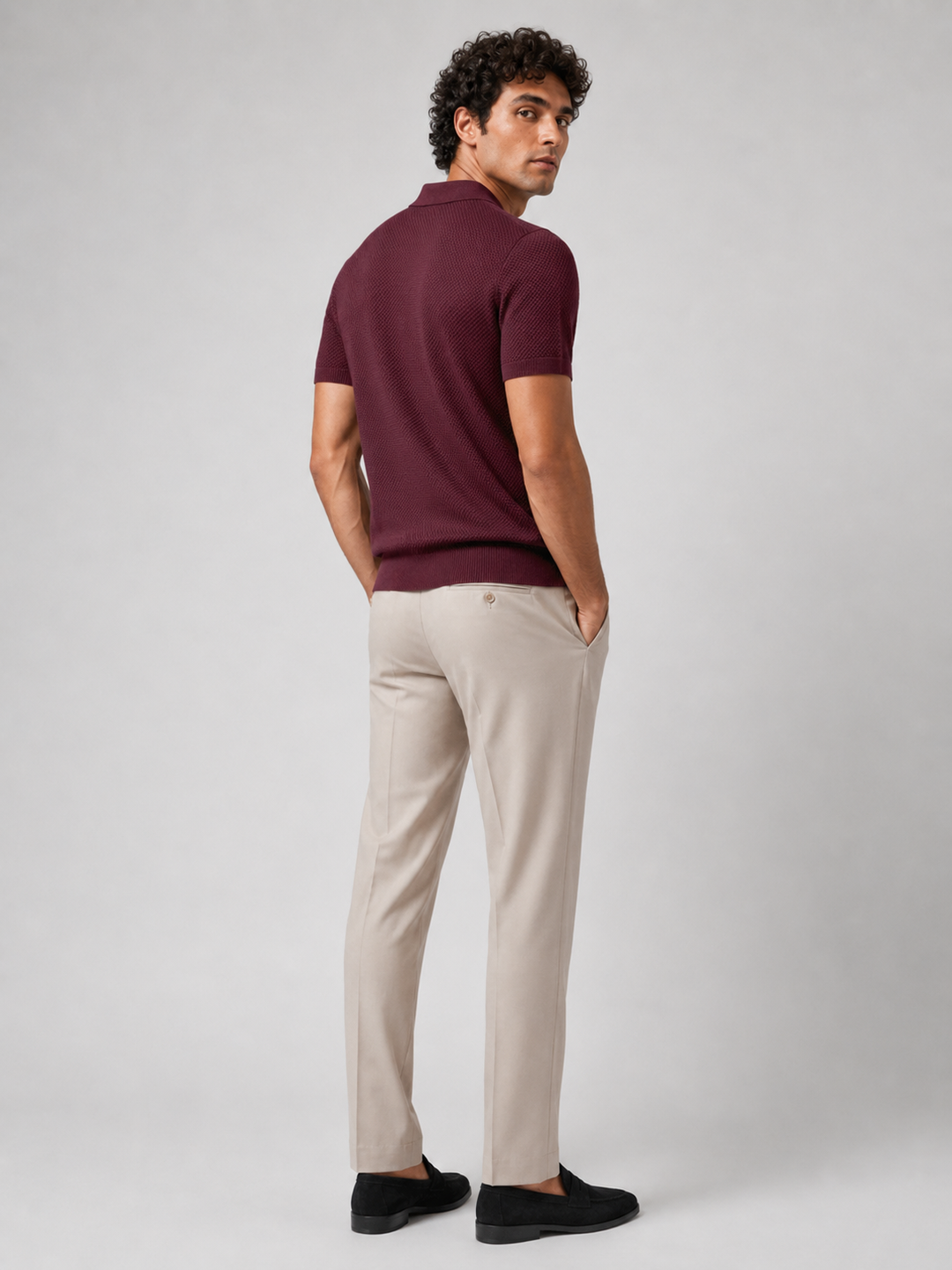 Vue de dos du polo bordeaux porté avec pantalon beige, l'homme regardant par-dessus l'épaule 24