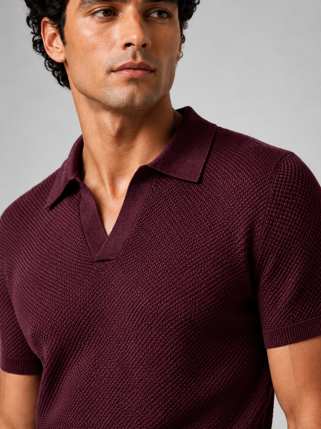 Gros plan sur le col et la maille texturée du polo bordeaux porté par un homme 22