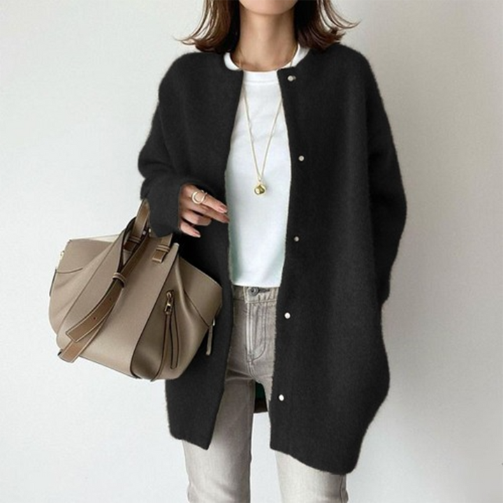 Gilet noir duveteux boutonné sur t-shirt blanc, porté avec jean gris clair et sac beige 4