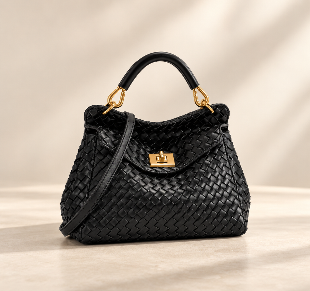 Sac noir en cuir tressé avec poignée rigide, fermoir doré et bandoulière, sur fond beige 3