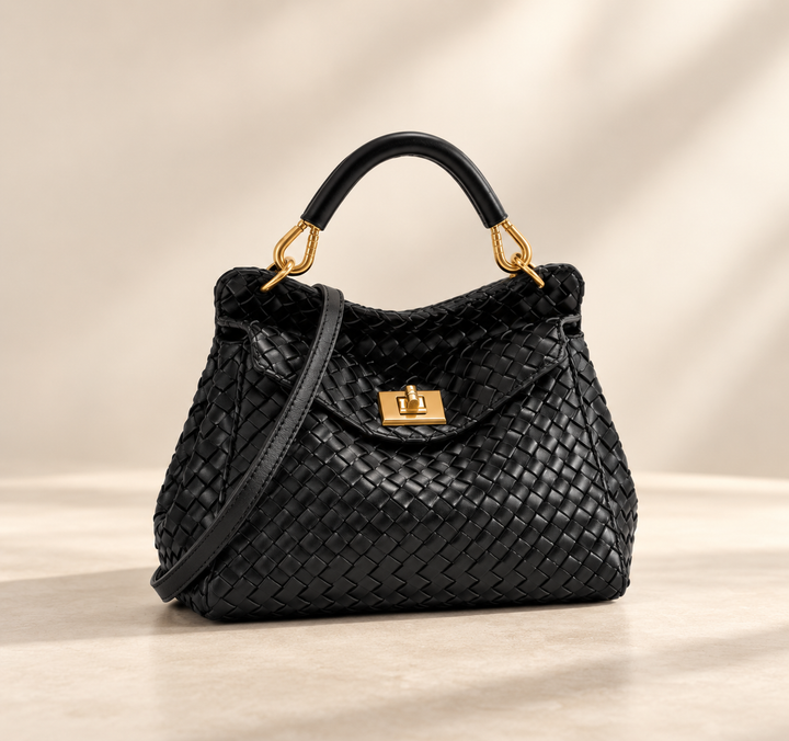 Sac noir en cuir tressé avec poignée rigide, fermoir doré et bandoulière, sur fond beige 3