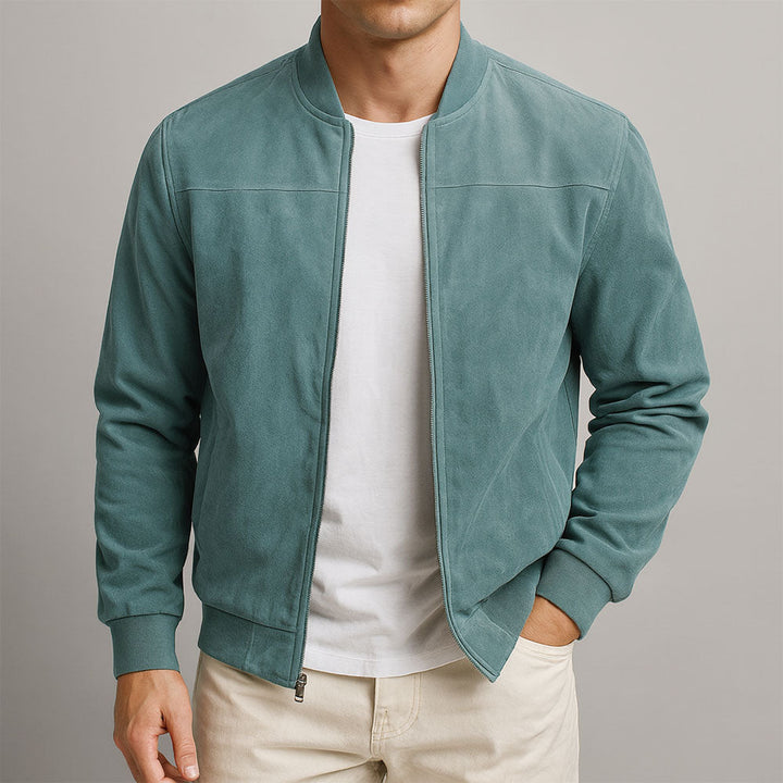 Homme portant le blouson en daim vert bleuté, zip ouvert sur un t-shirt blanc, vue de face, une main en poche. 3