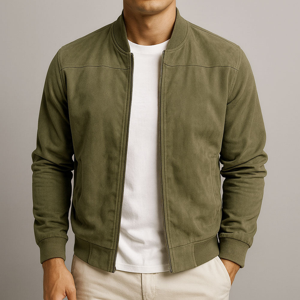 Homme portant le blouson en daim vert kaki, zip ouvert sur un t-shirt blanc, vue de face avec un pantalon beige. 4