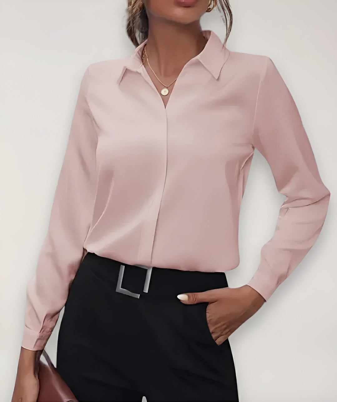 Chemisier rose pâle porté par une mannequin, main dans la poche du pantalon noir 2