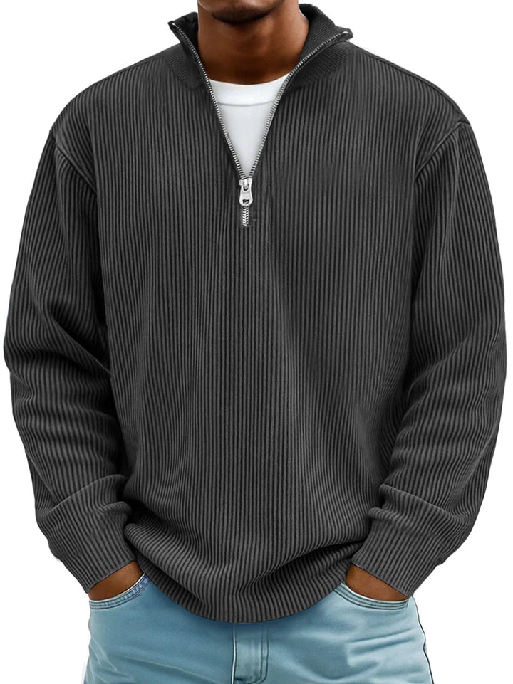 Pull côtelé gris anthracite à demi-zip, porté de face par un homme avec t-shirt blanc et jean clair. 4