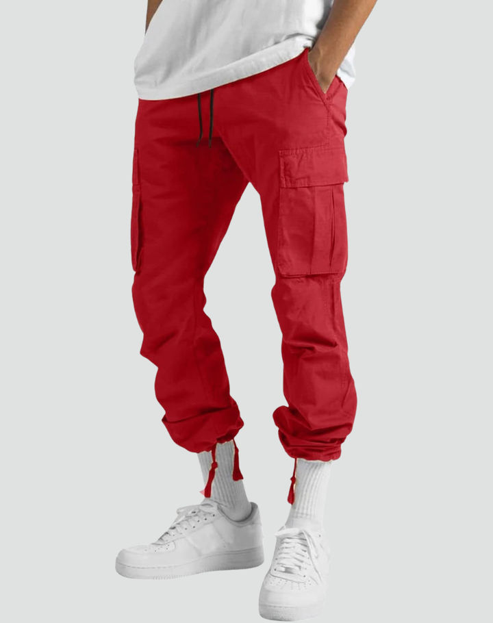 Pantalon cargo rouge vu de face sur un modèle, bas de jambe resserré par cordons, chaussettes blanches et baskets blanches. 11