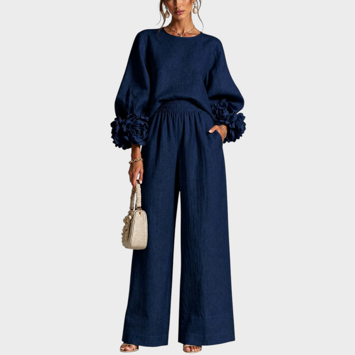 Ensemble bleu marine porté de face, manches à fleurs en relief, une main dans la poche 2