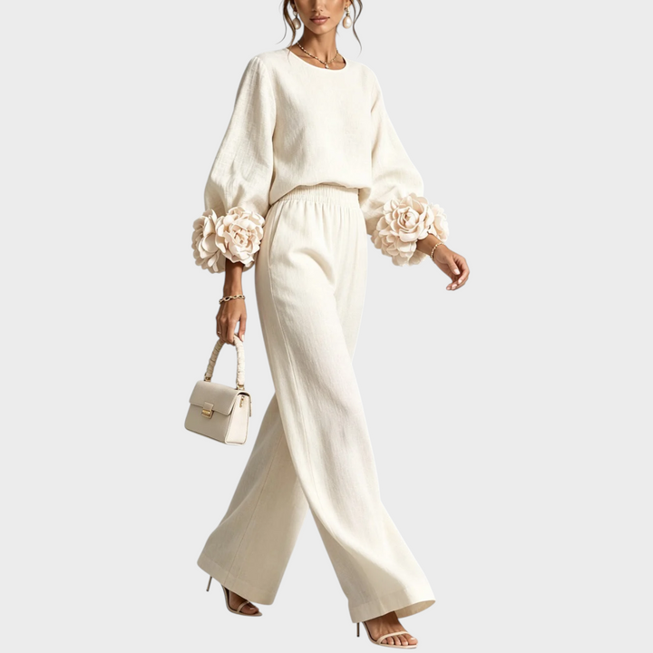 Ensemble crème porté en marchant, fleurs volumineuses aux poignets et pantalon fluide à taille élastiquée 5