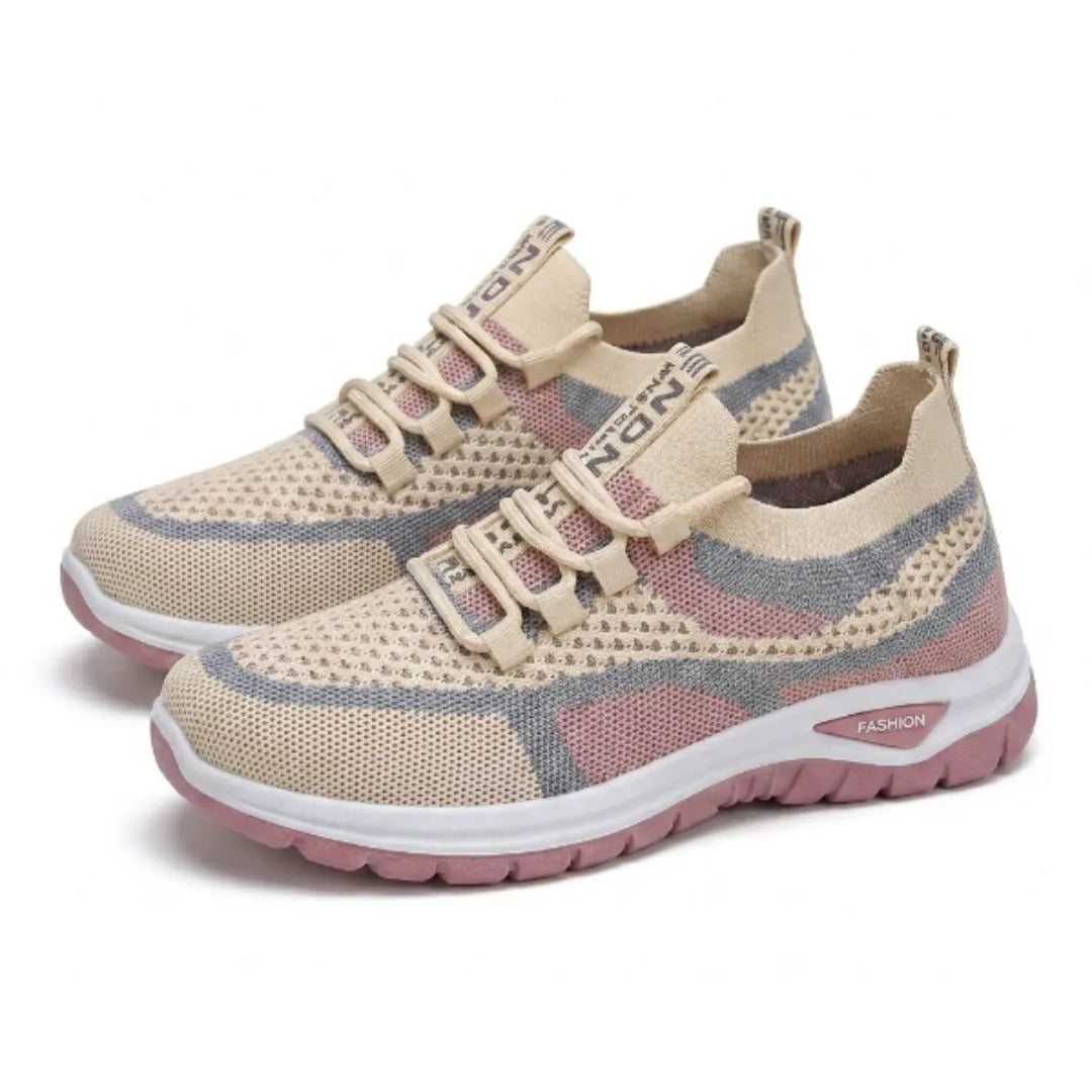 Paire de baskets en mesh beige, rose et gris-bleu, posée en vue trois quarts, avec lacets élastiques beiges et semelle rose. 34