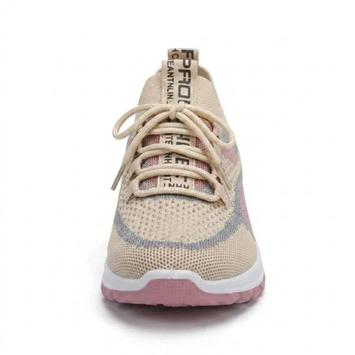 Vue de face d'une basket en mesh beige, rose et gris, montrant les lacets beiges, la languette imprimée et le bout arrondi. 35