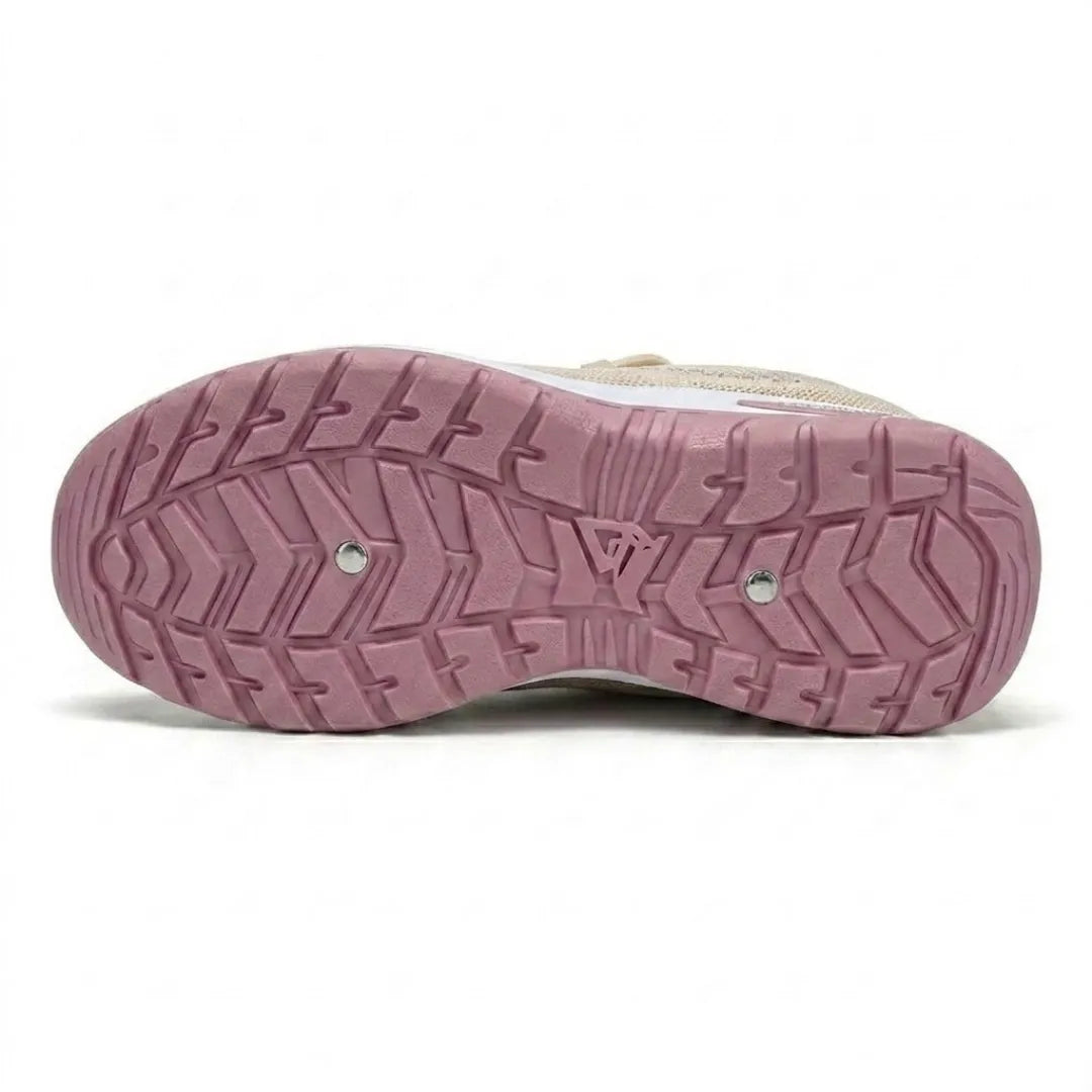 Dessous de la semelle rose d'une basket beige, avec ses crampons en chevrons et deux petits rivets métalliques. 36