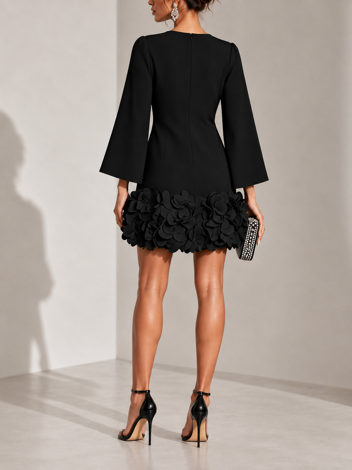 Robe noire vue de dos avec fermeture zippée, manches évasées et bas orné de fleurs en relief. 3