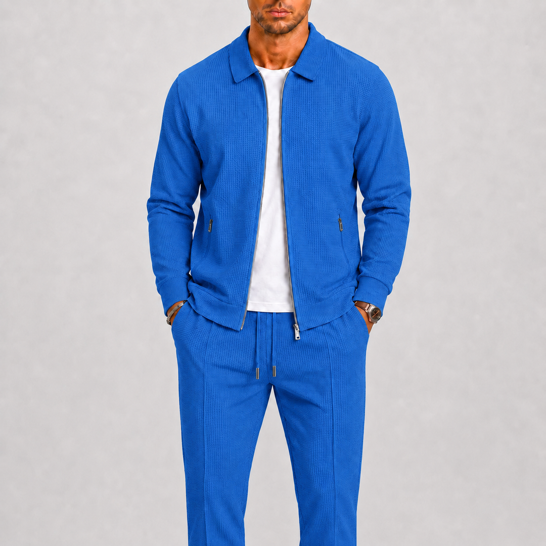 Homme portant l'ensemble bleu vif en maille gaufrée, veste zippée ouverte sur un t-shirt blanc 5