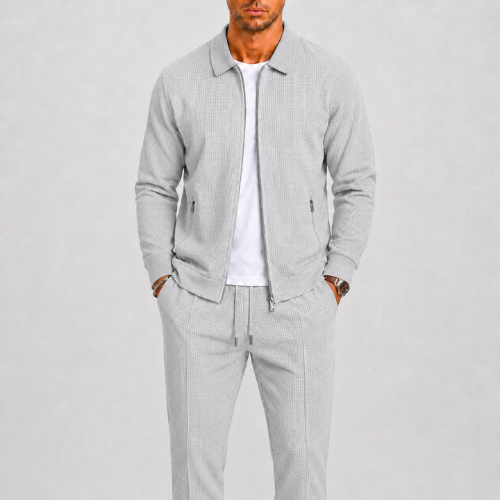 Homme portant l'ensemble gris clair en maille gaufrée, veste zippée ouverte sur un t-shirt blanc 4