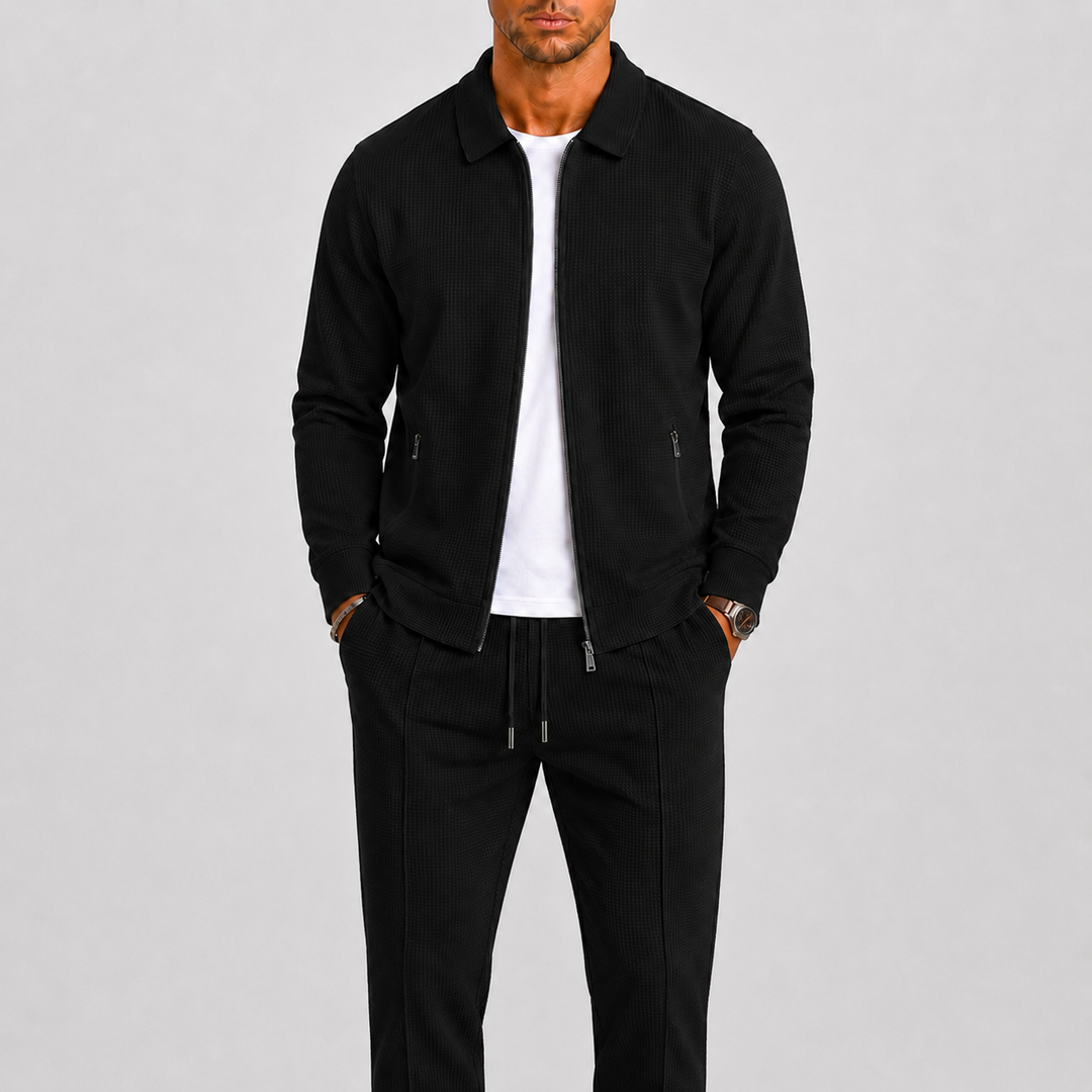 Homme portant l'ensemble noir en maille gaufrée, veste zippée ouverte sur un t-shirt blanc 3