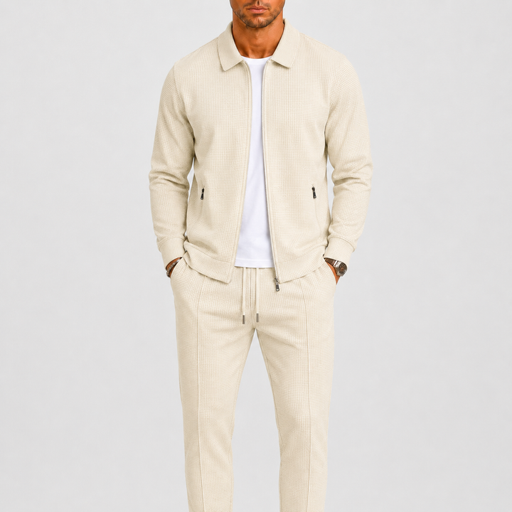 Homme portant l'ensemble beige en maille gaufrée, veste zippée ouverte sur un t-shirt blanc 1