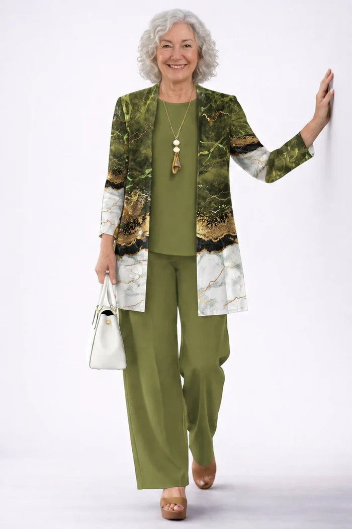 Femme aux cheveux blancs, ensemble vert olive, cardigan effet marbre vert, noir, doré et blanc, main au mur 12
