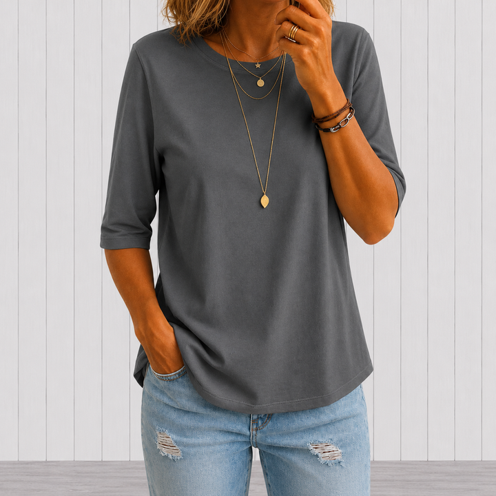 T-shirt gris foncé à demi-manches porté avec un jean troué, plan plus large et fond de panneaux blancs. 7