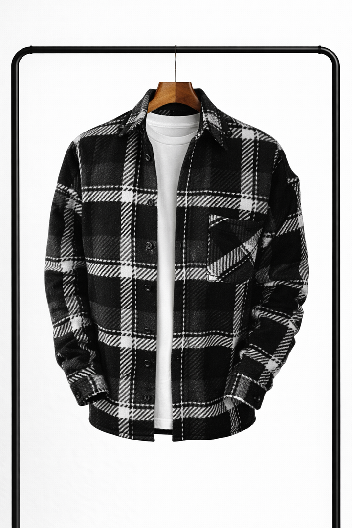 Surchemise à carreaux noirs, blancs et gris, suspendue ouverte sur un t-shirt blanc, vue de face avec poche poitrine. 3