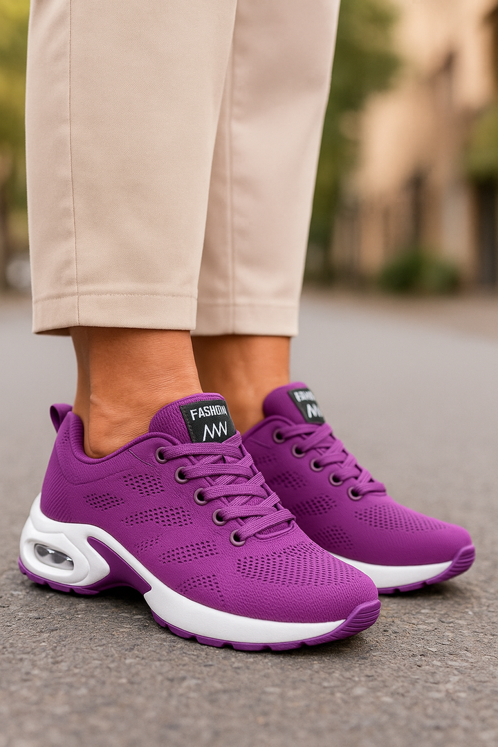 Baskets violettes en maille perforée à semelle blanche avec bulle d'air, portées avec un pantalon beige. 7