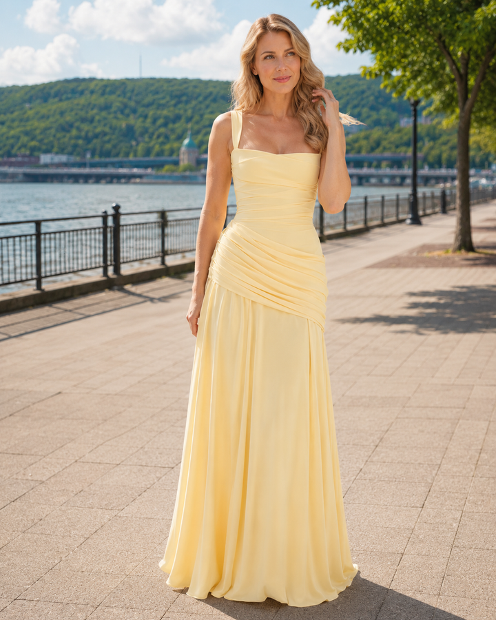 Robe jaune pâle portée par une femme blonde sur une promenade au bord de l'eau, en plein soleil. 1
